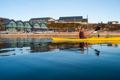 a man in a yellow kayak on the water at Panorama Rorbusuiter in Steinsland