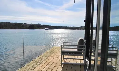 a boat deck with a bench and the water at Panorama Rorbusuiter in Steinsland