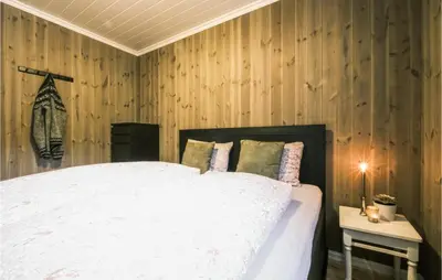 a bedroom with a white bed with wooden walls at Stunning Home In Rauland With Wifi in Rauland