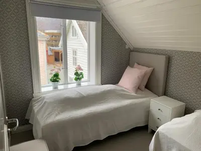 a small bedroom with a bed and a window at Old town boutiqe apartments/ Gamle Lærdalsøyri boutique leiligheter in Lærdalsøyri