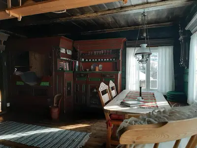 a dining room with a table and chairs and a window at Gamlestugu Greivjord Fjellgard in Tuddal