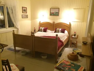 a bedroom with a wooden bed with pillows on it at Strømnes - Oldefars gjestehus Inderøy in Straumen