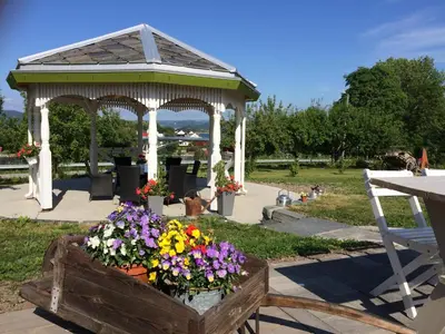 a gazebo with flowers in a wooden box at Strømnes - Oldefars gjestehus Inderøy in Straumen
