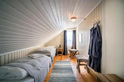 two beds in a room with a ceiling at Flatflesa Fyr - by Classic Norway Hotels in Rindarøy