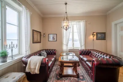 a living room with two leather couches and a table at Flatflesa Fyr - by Classic Norway Hotels in Rindarøy
