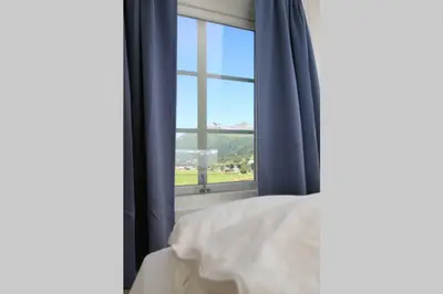 a bedroom with a bed and a large window at Bellahuset in Sæbø