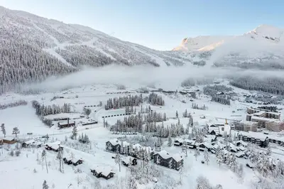 a town covered in snow with a mountain in the background at Tinden in Hemsedal