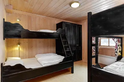 two bunk beds in a room with wooden walls at Tinden in Hemsedal