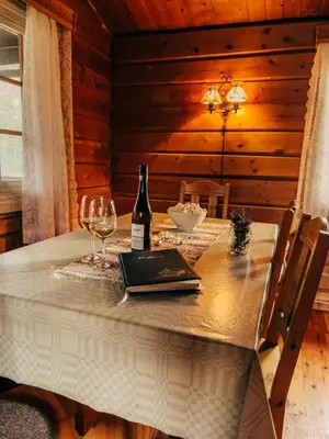 a table with a bottle of wine and a book at Ryen Hytteutleie - Cottages in Røros