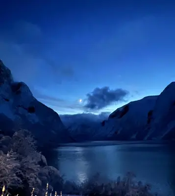 a moon rising over a mountain lake at night at Iris Vedal in Nauste