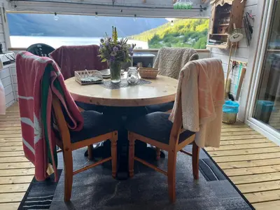 a wooden table and chairs on a patio at Iris Vedal in Nauste