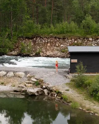 a little girl standing in front of a river at Jølstraholmen Landskapshotell in Vassenden