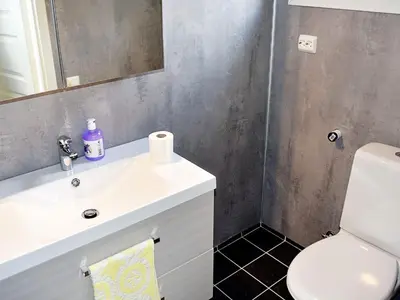 a bathroom with a sink and a toilet and a mirror at 6 person holiday home in VATNE in Vatne