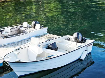 two white boats docked at a dock in the water at 6 person holiday home in VATNE in Vatne