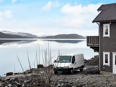 a white van parked next to a body of water at 8 person holiday home in VATNE in Vatne