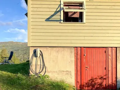 a building with a red door and a window at Secluded Mountain Retreat-By Traum in Vassenden