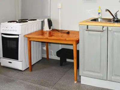 a kitchen with a wooden table with a stove and a sink at Secluded Mountain Retreat-By Traum in Vassenden