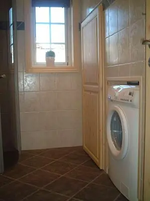 a washing machine in a bathroom with a window at Mugnablikk in Beitostøl