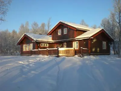 a large wooden house with snow in front of it at Mugnablikk in Beitostøl