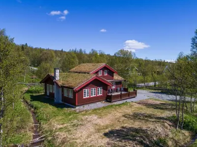 a large red house with a grass roof at Mugnablikk in Beitostøl