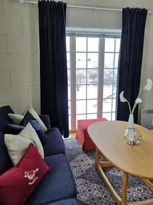 a living room with a blue couch and a table at Sanner Hotell in Gran