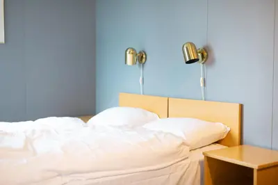 a bed with white sheets and pillows next to a table at Havly Bed & Breakfast in Hauge