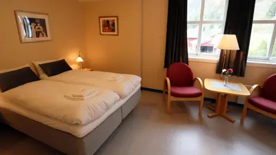 a hotel room with a bed and a table and chairs at Havly Bed & Breakfast in Hauge