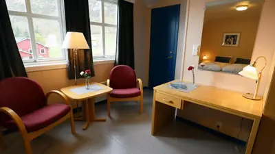 a room with a desk and two chairs and a bed at Havly Bed & Breakfast in Hauge