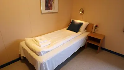 a small bed in a room with a night stand at Havly Bed & Breakfast in Hauge