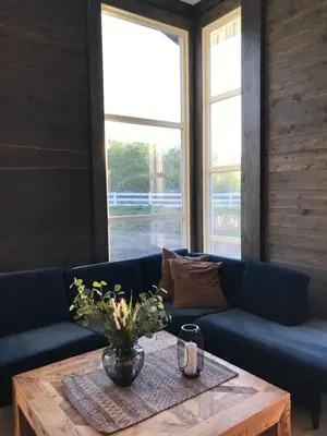 a living room with a blue couch and a wooden table at Fjelleventyret gårdsovernatting in Skjåk
