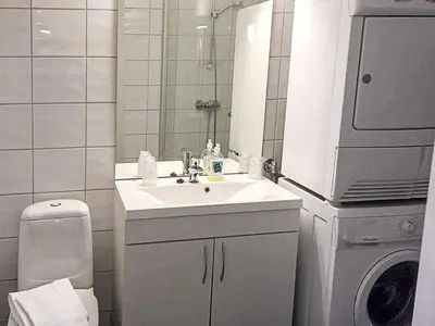 a bathroom with a sink and a washing machine at 6 person holiday home in Austrheim in Utkeila