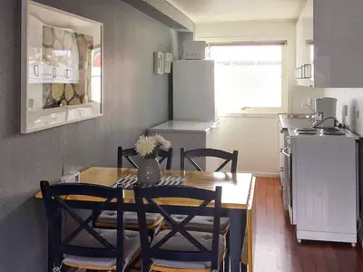 a kitchen with a wooden table and chairs and a kitchen with a table at 6 person holiday home in Austrheim in Utkeila