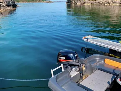 a boat is tied up to the dock on the water at 6 person holiday home in Austrheim in Utkeila