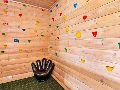 a room with a rock climbing wall with a leather chair at 12 person holiday home in Fitjar in Fitjar