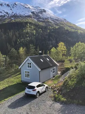 a white car parked in front of a house at Tunold Gård - Freden in Stryn