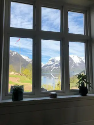 a window with a view of snow capped mountains at Tunold Gård - Freden in Stryn