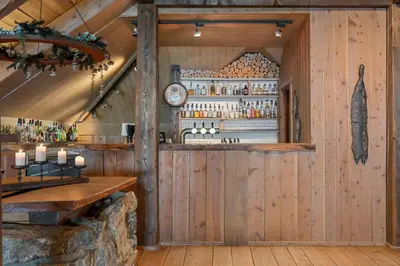 a bar in a cabin with wooden walls at Øyna Kulturlandskapshotell in Straumen