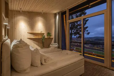a bedroom with a large bed and a large window at Øyna Kulturlandskapshotell in Straumen
