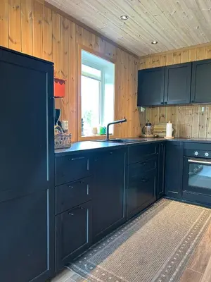 a kitchen with dark blue cabinets and a window at Tuddal Hyttegrend HYTTA KÅNS in Tuddal