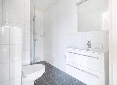 a white bathroom with a toilet and a sink at Aursnes Hotell in Sykkylven