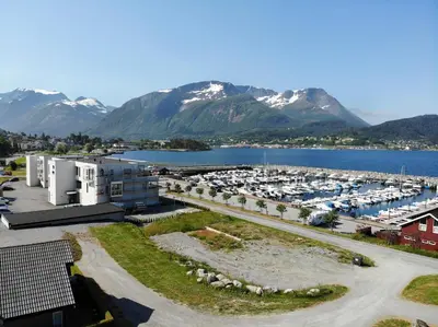 an aerial view of a marina with snow covered mountains at Aursnes Hotell in Sykkylven