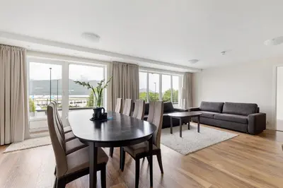 a living room with a table and chairs and a couch at Aursnes Hotell in Sykkylven