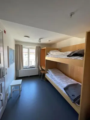 a room with two bunk beds and a table at Falstadsenteret - Museum, minnested og senter for menneskerettigheter in Levanger