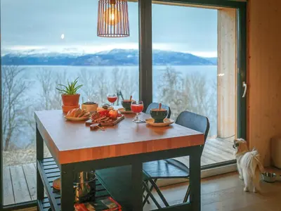 a dining room table with a view of the water at Hardanger Fjordtun PANORAMA cabin near the Hardangerfjord with fantastic fjordview, silence and nature in Herand
