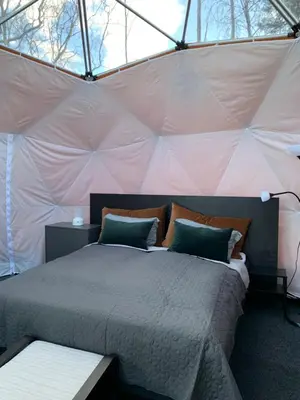 a bedroom with a bed in a tent at FUGELVÅGEN, cabins and glamping in Ålvundfjord