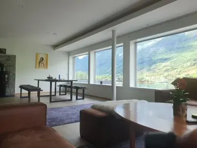 a living room with a table and some windows at Olden Panorama Apartments - Fjord view - High Standard in Olden