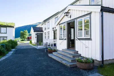 a white house with stairs leading to the front door at Kongsvold Fjeldstue by Frich`s in Oppdal