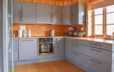 a kitchen with white appliances and a wooden wall at Stordalen in Bjordal
