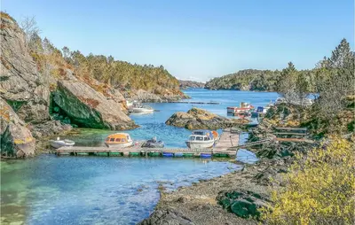 a bunch of boats are docked in a river at Amazing Apartment In Fjell in Lokøy