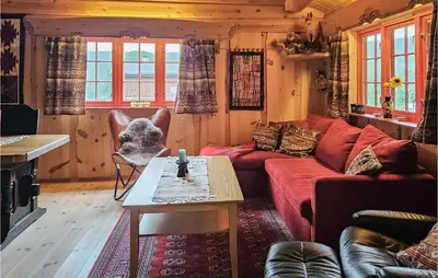 a living room with a red couch and a table at 3 Bedroom Lovely Home In Nordberg in Skjåk